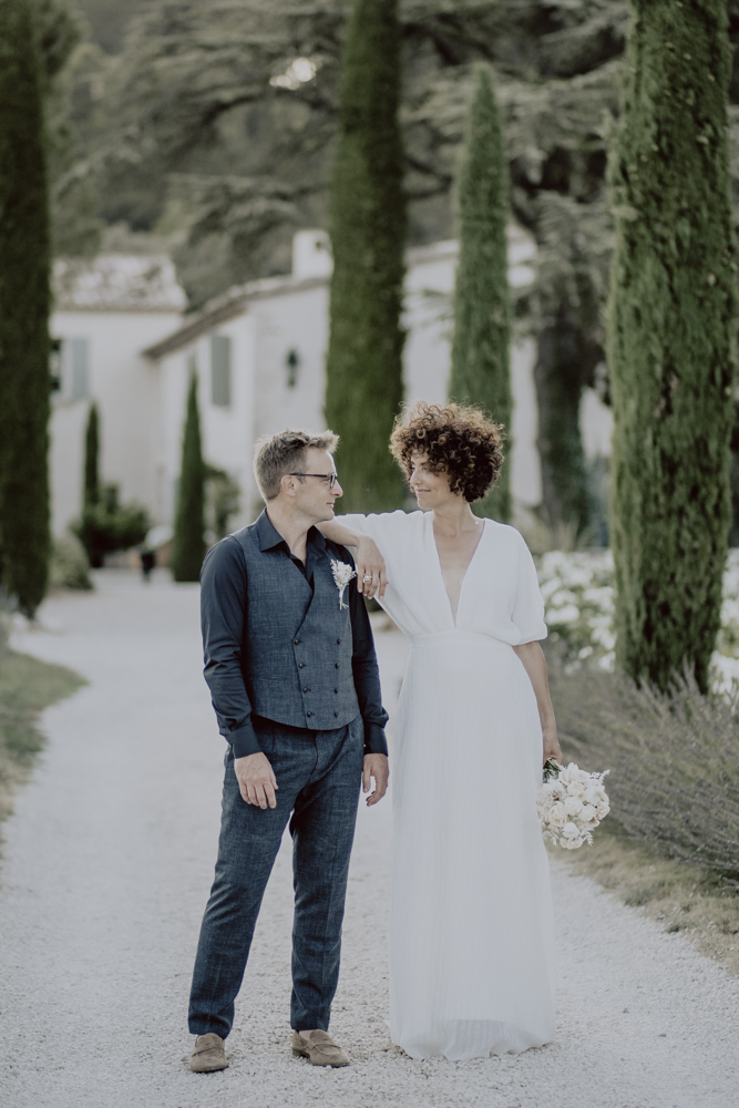 couple de mariés dans une allée de cyprès florentins