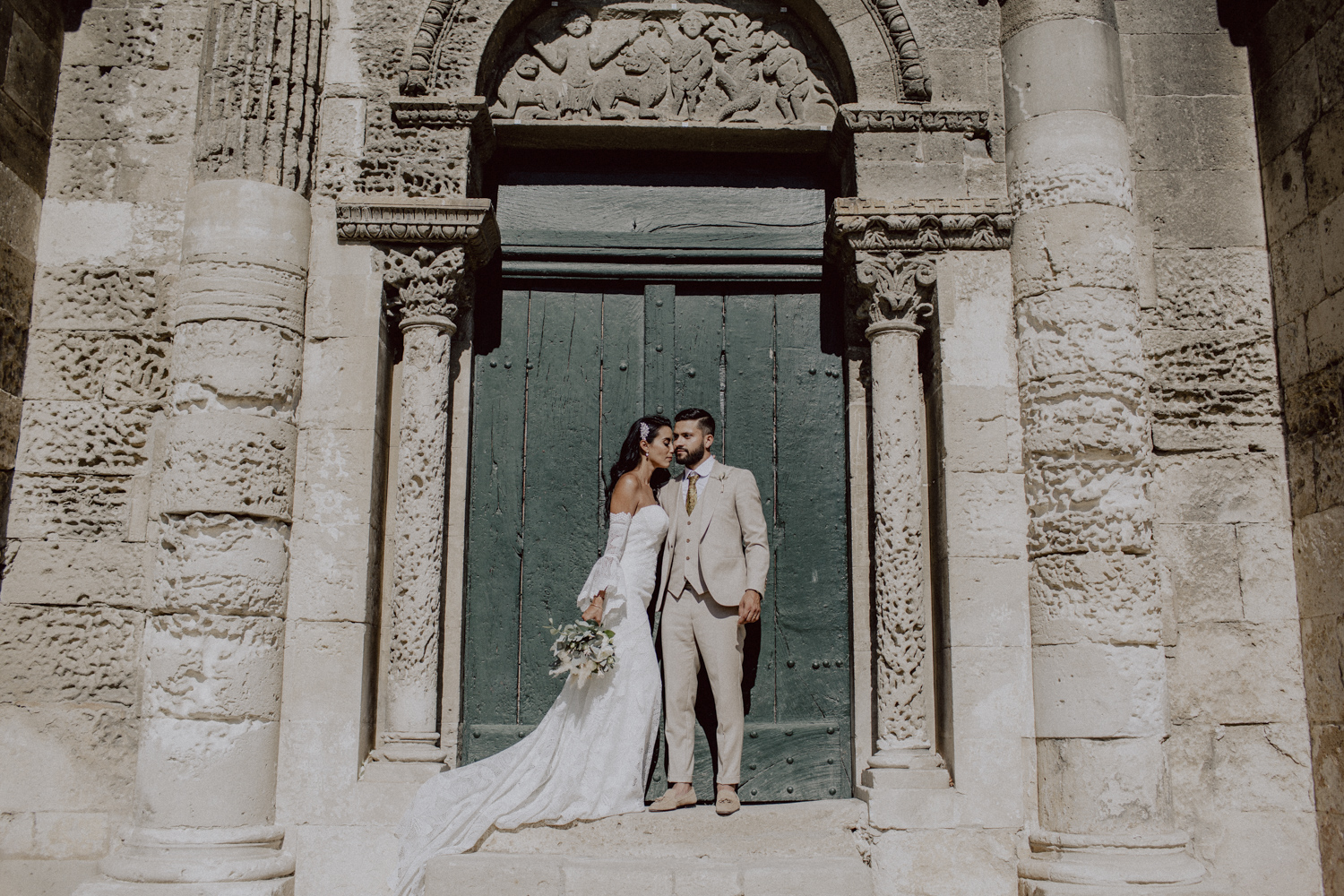 couple de mariés qui s'embrassent devant une église
