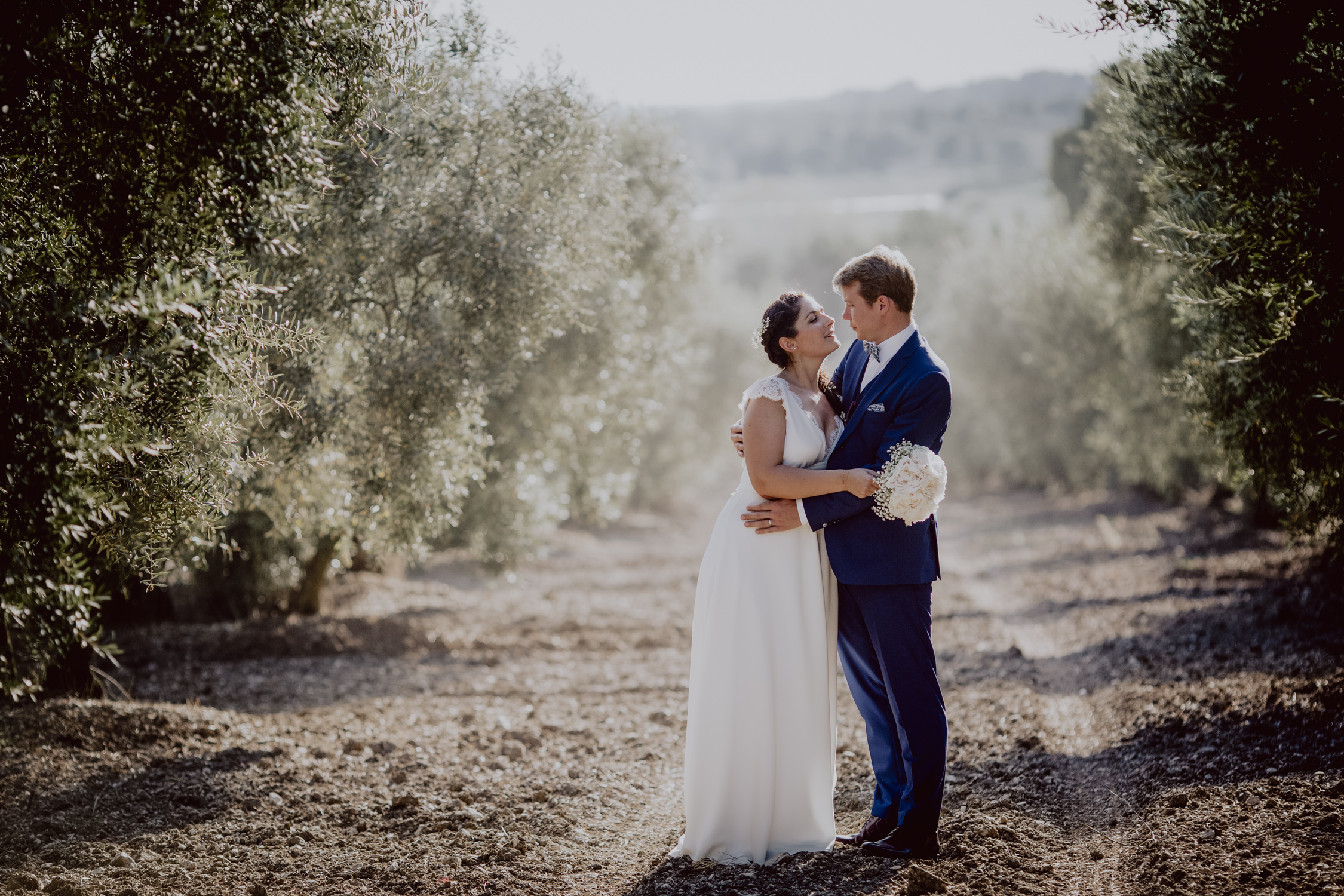 couple de mariés dans un champ d'olivier