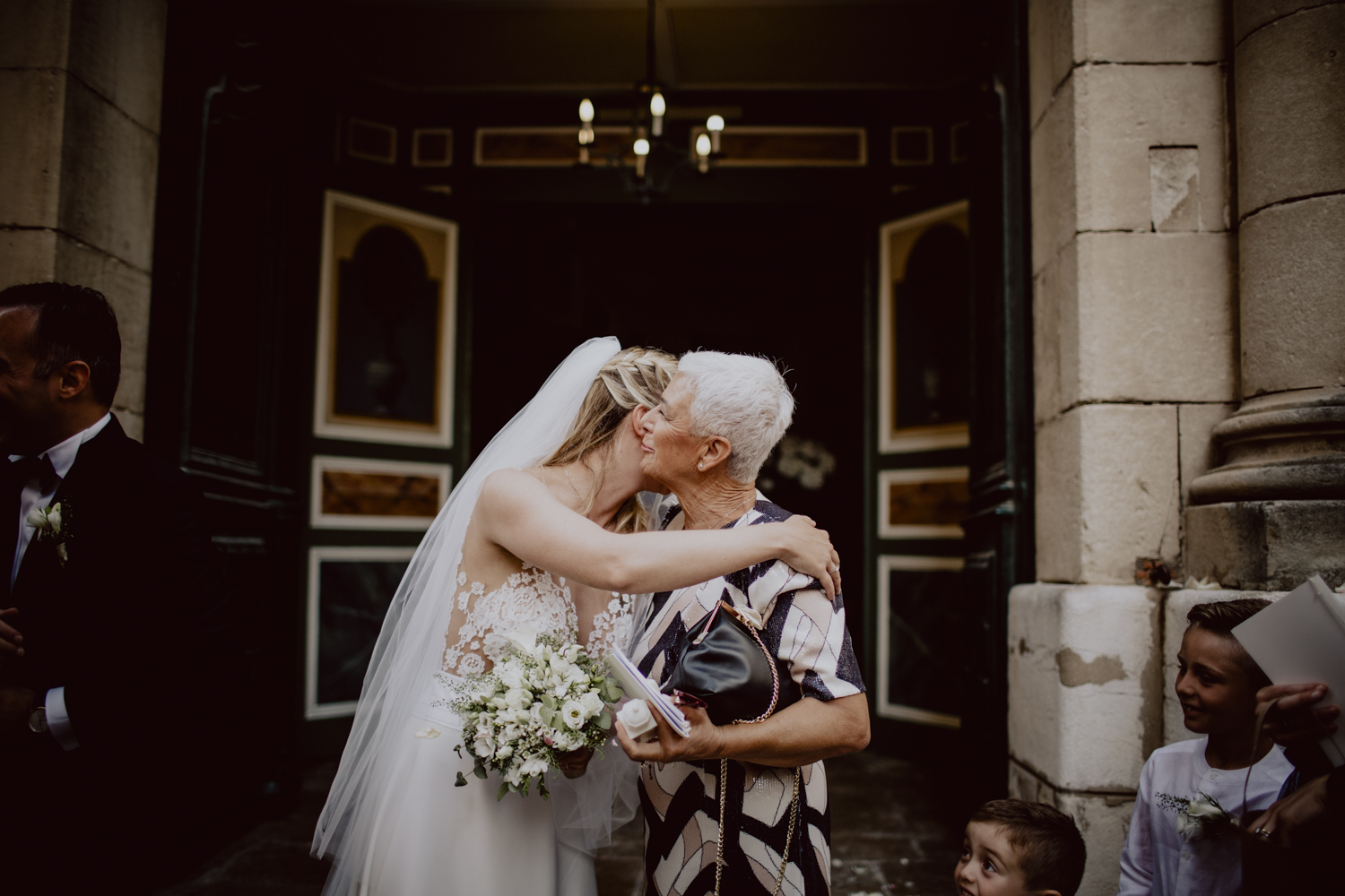la mariée à la sortie de l'église qui embrasse sa mère