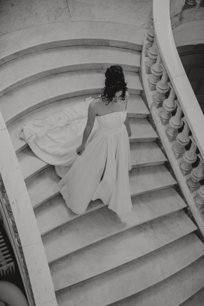 Photo de mariage en noir et blanc de la mariée descendant l'escalier monumental en marbre de la Villa Rocabella