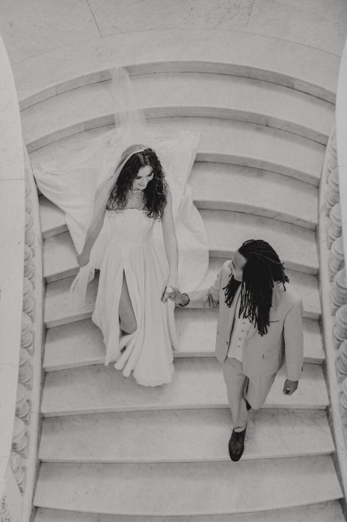 Photo de mariage en noir et blanc du couple descendant l'escalier monumental en marbre de la Villa Rocabella